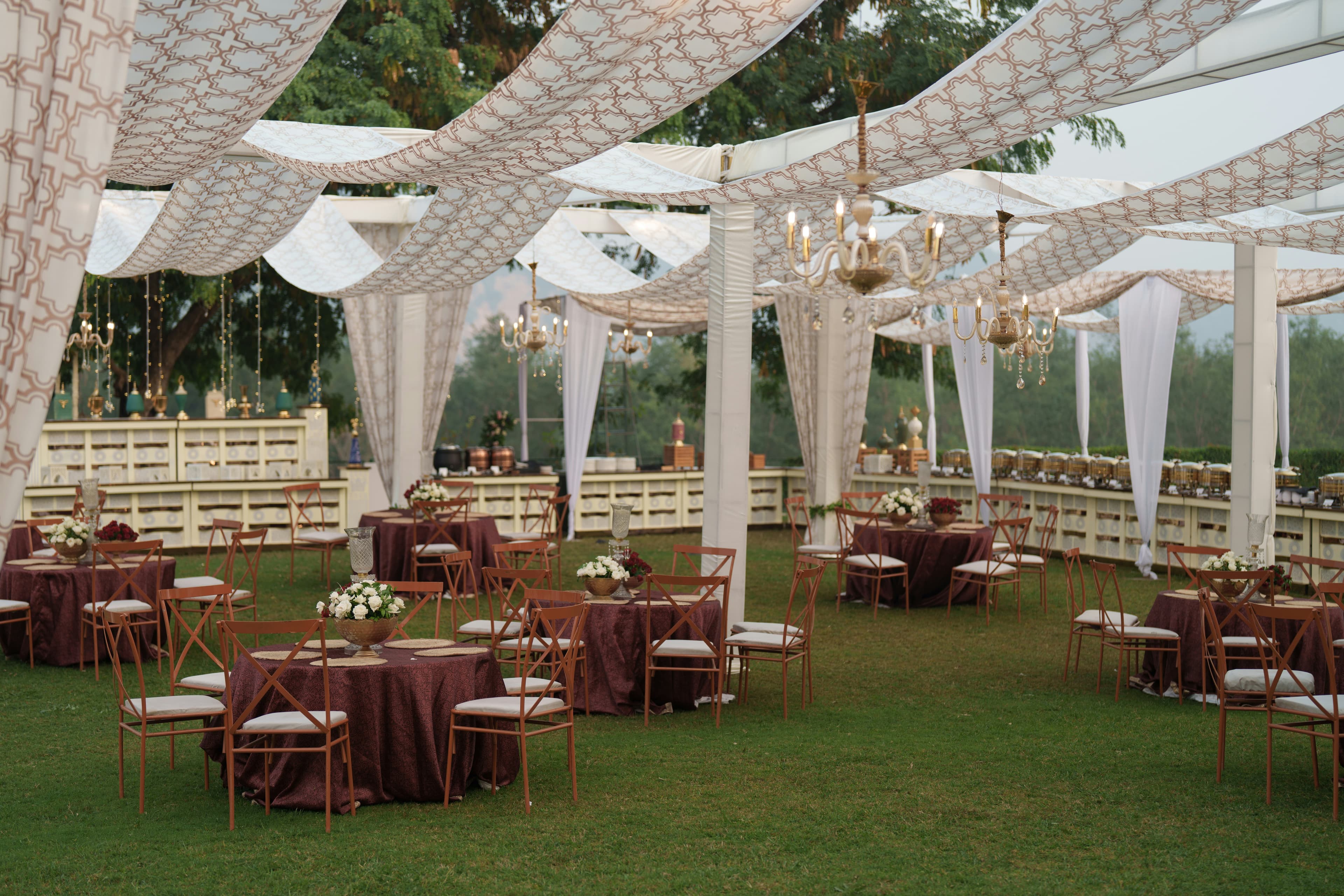 Outdoor wedding reception with draped canopies