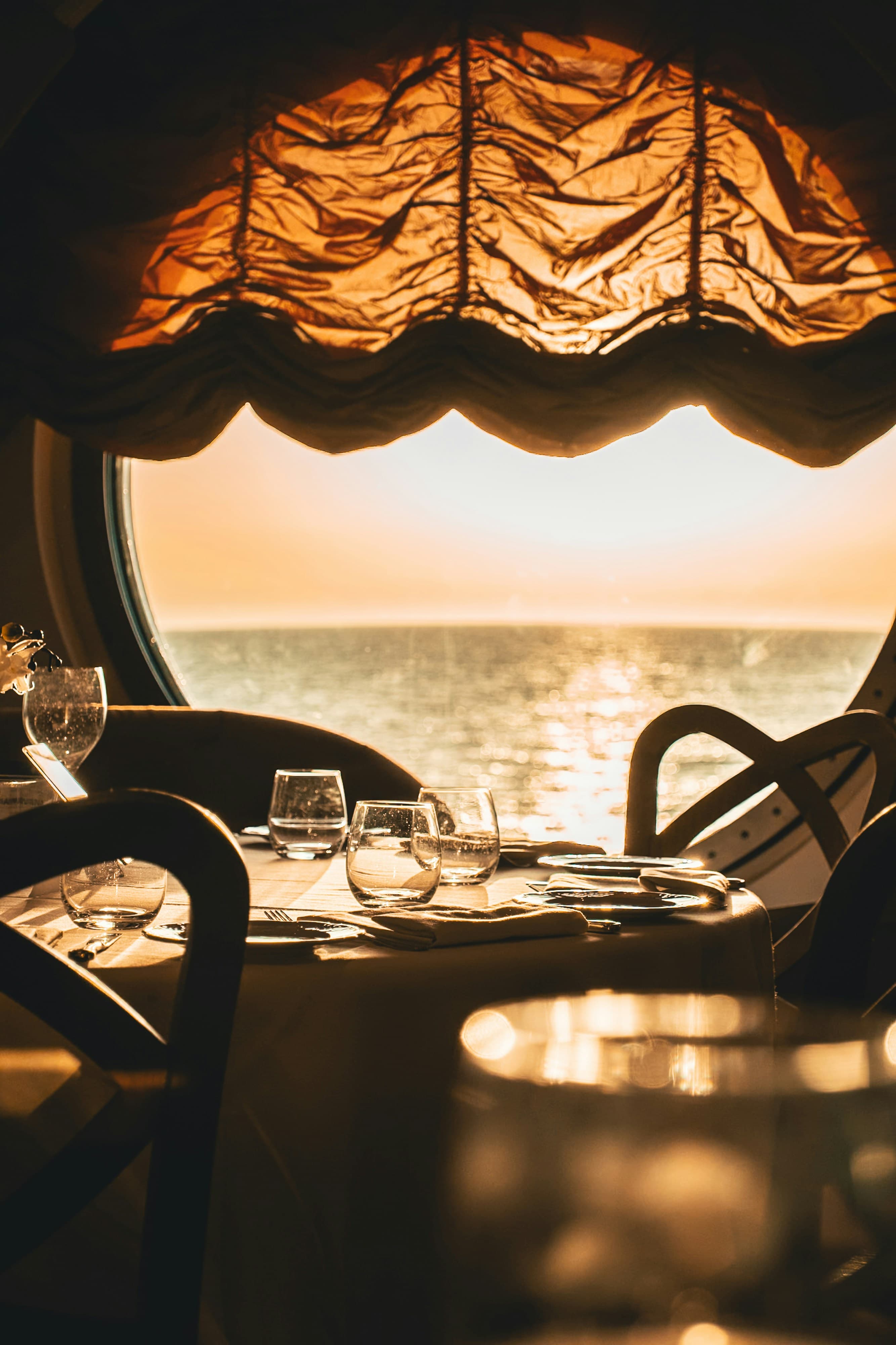 Dinner table by a cruise window at sunset